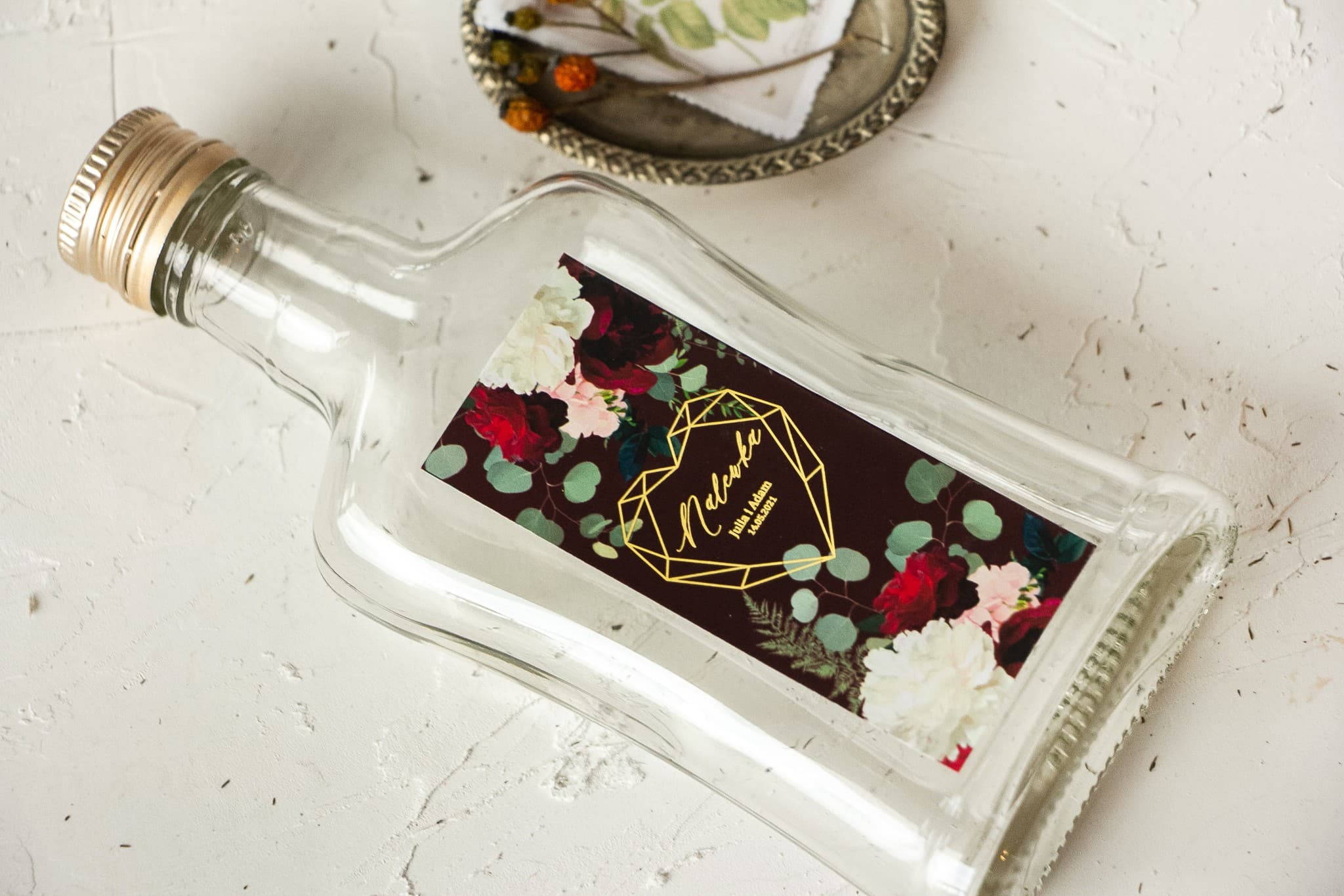 Podziękowania dla gości w formie buteleczki na nalewki z czerwoną różą i złoceniem Szafirowe nr 9